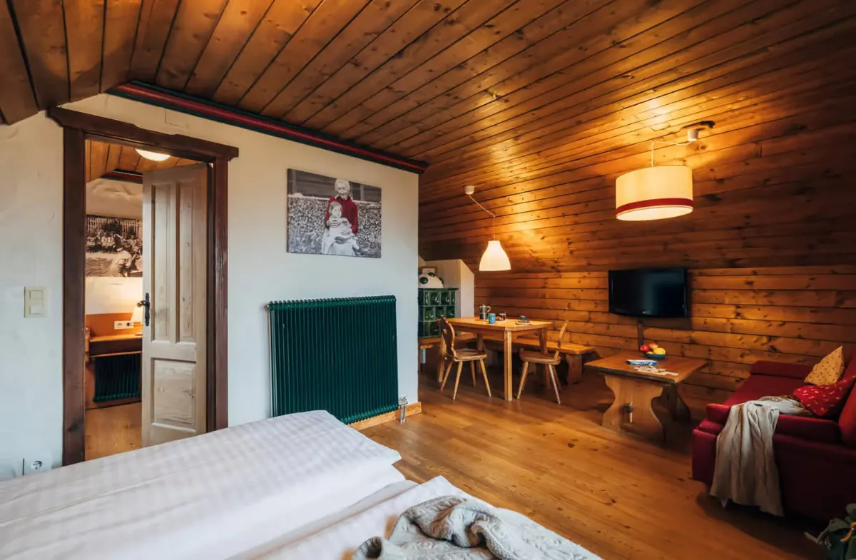 Rosennock-Wohnung mit Bett, Holzwänden und Essplatz