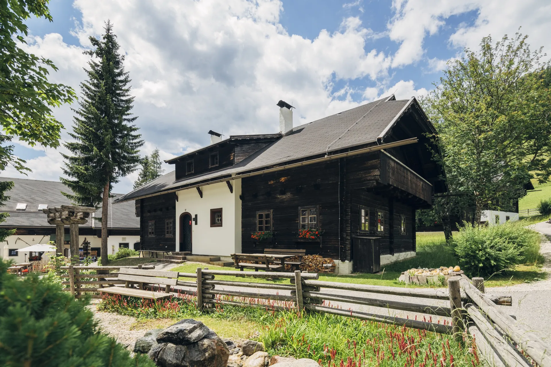 Holzhaus mit Zaun und Wiese im Sommer