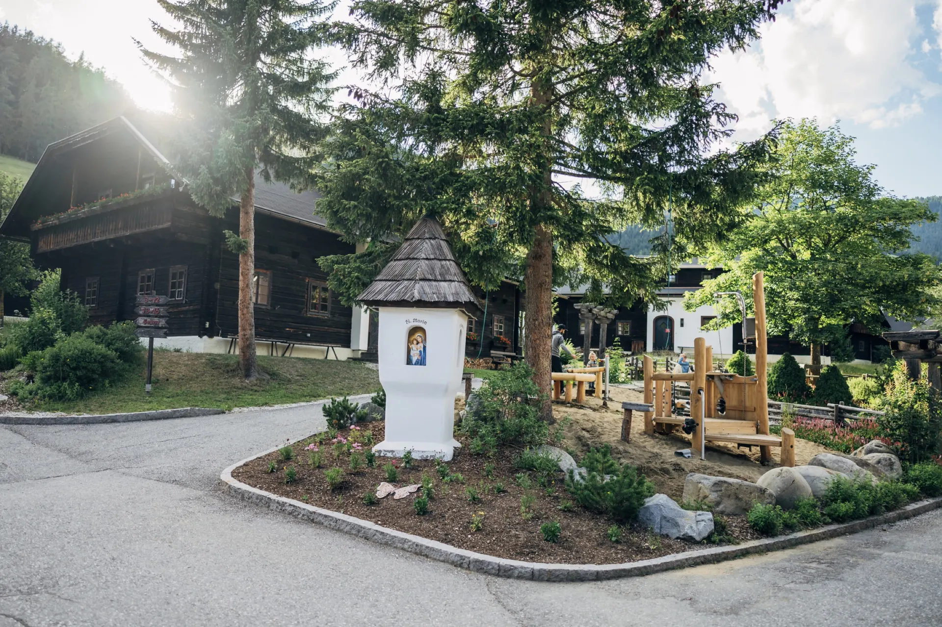 Bildstock und Holzspielplatz zwischen den Häusern