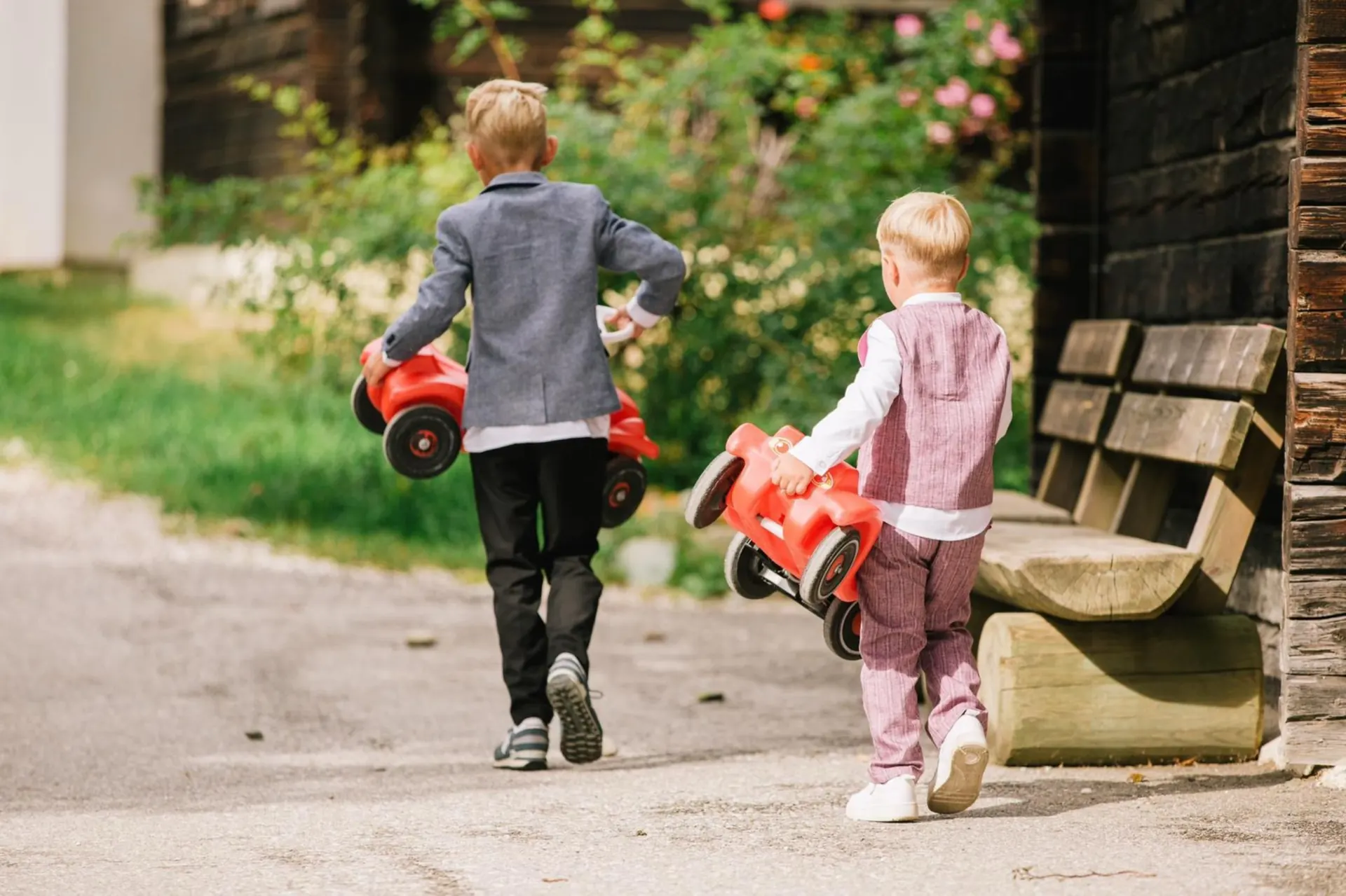 Kinder mit Bobbycar am Weg