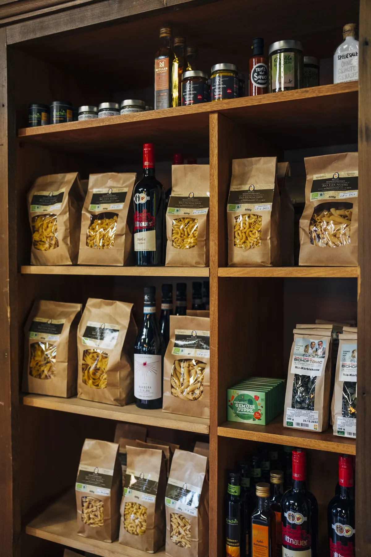 Regal mit Nudeln, Wein und Gläsern