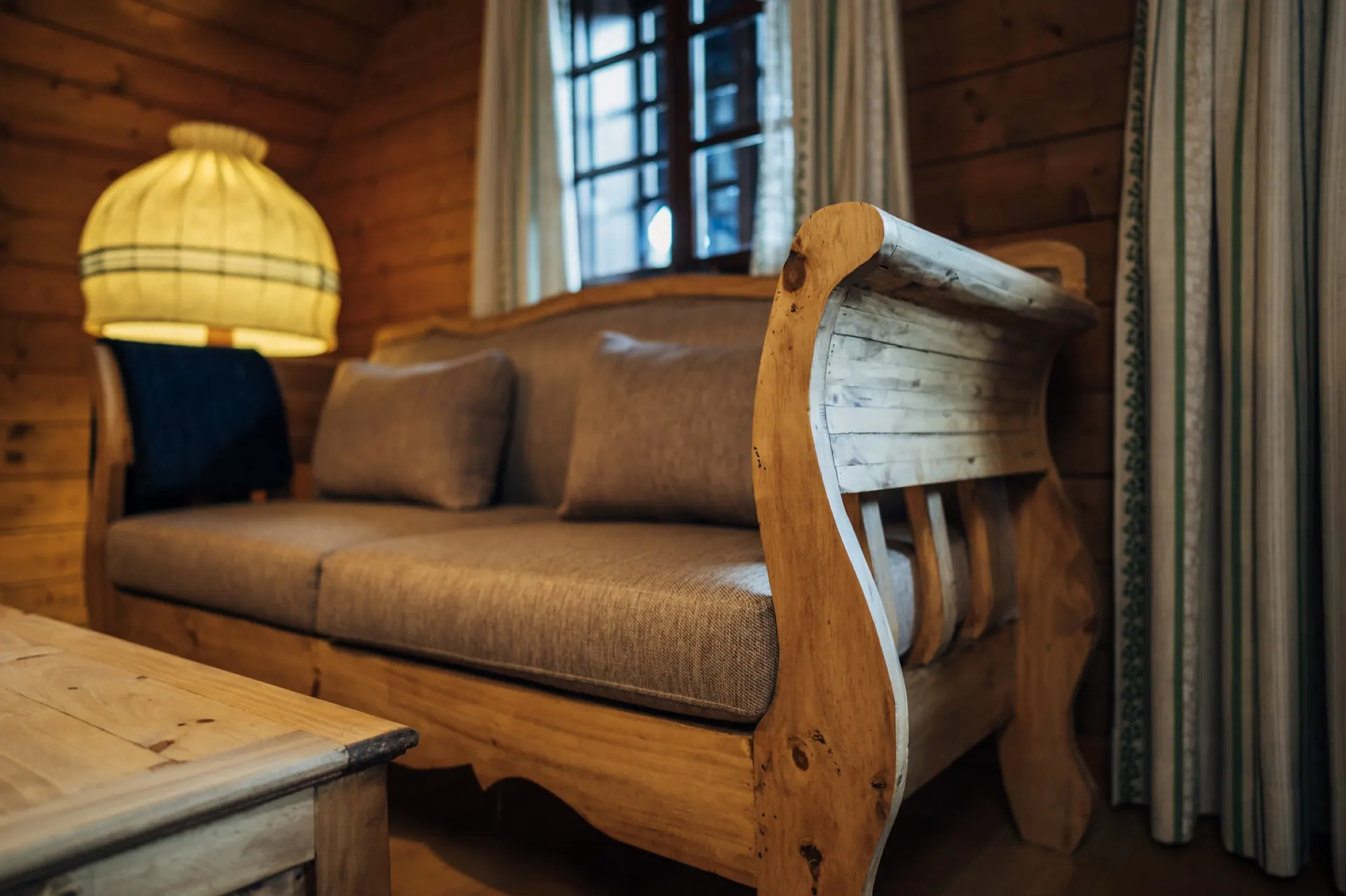 Sofa mit Holzrahmen vor dem Fenster