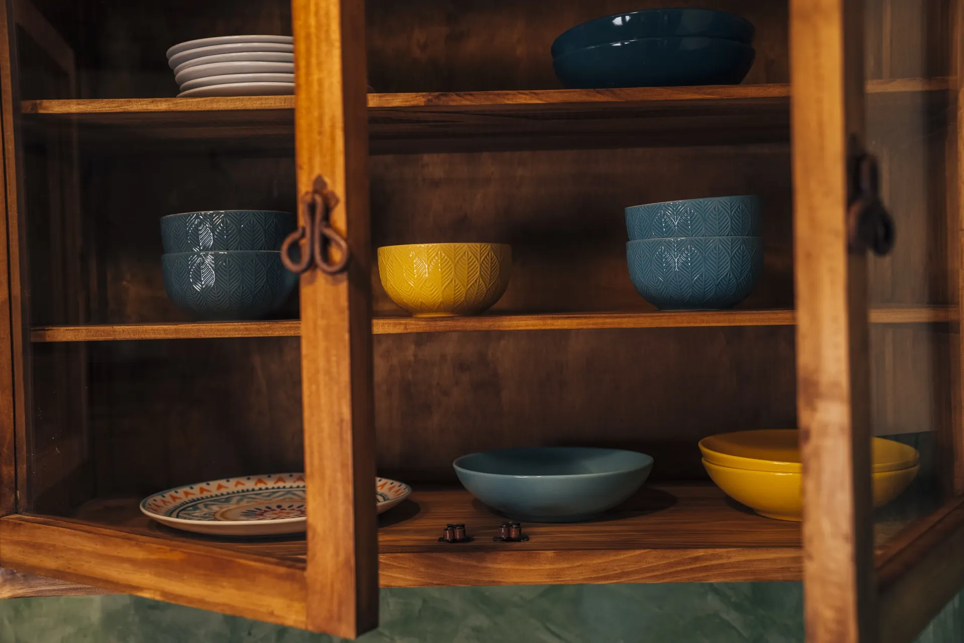 Küchenschrank mit blauem und gelbem Geschirr