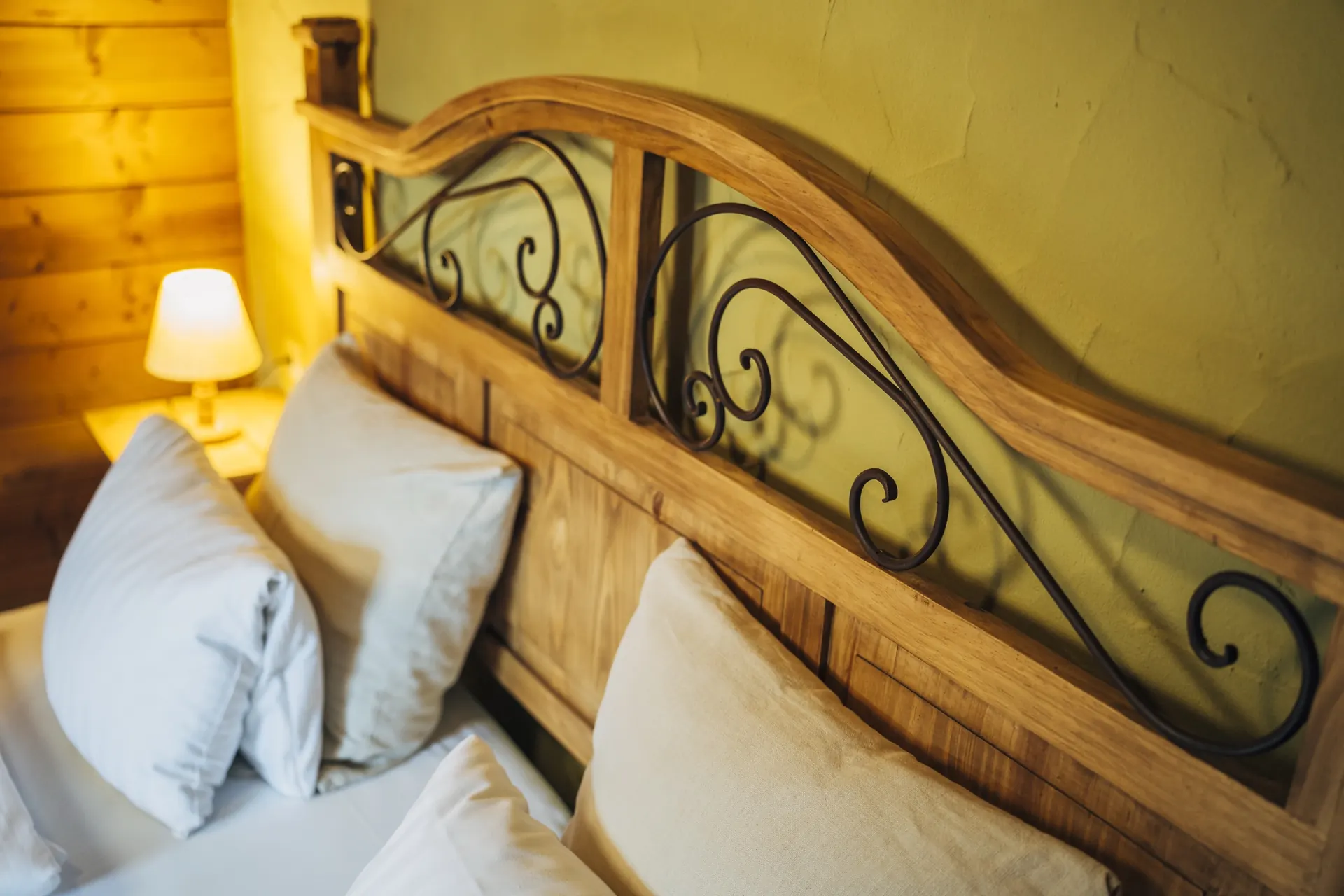 Kopfteil aus Holz und Schmiedeeisen am Bett