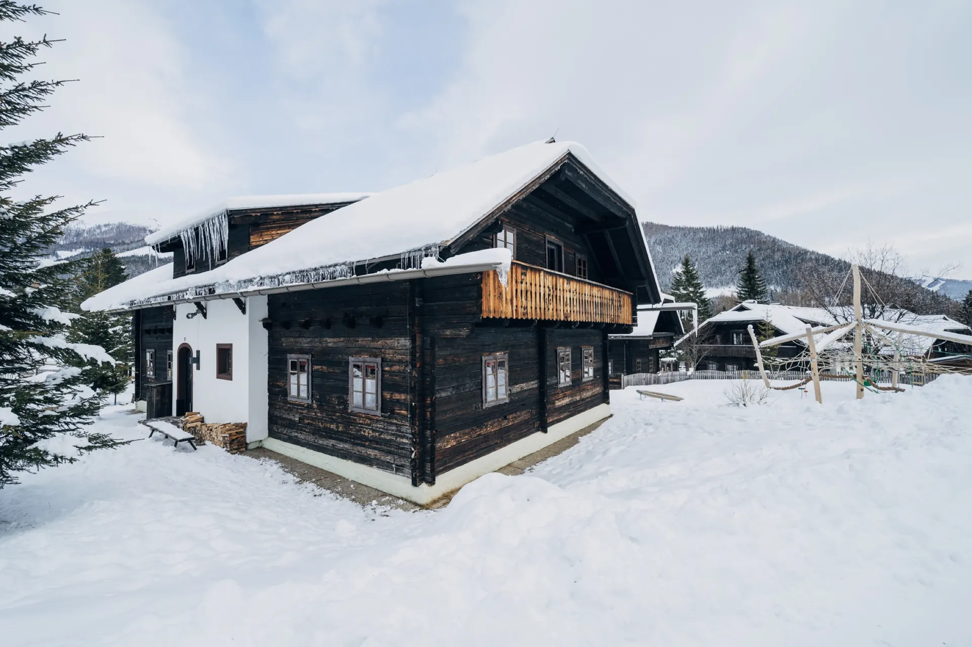 Verschneites Holzhaus mit weißem Sockel