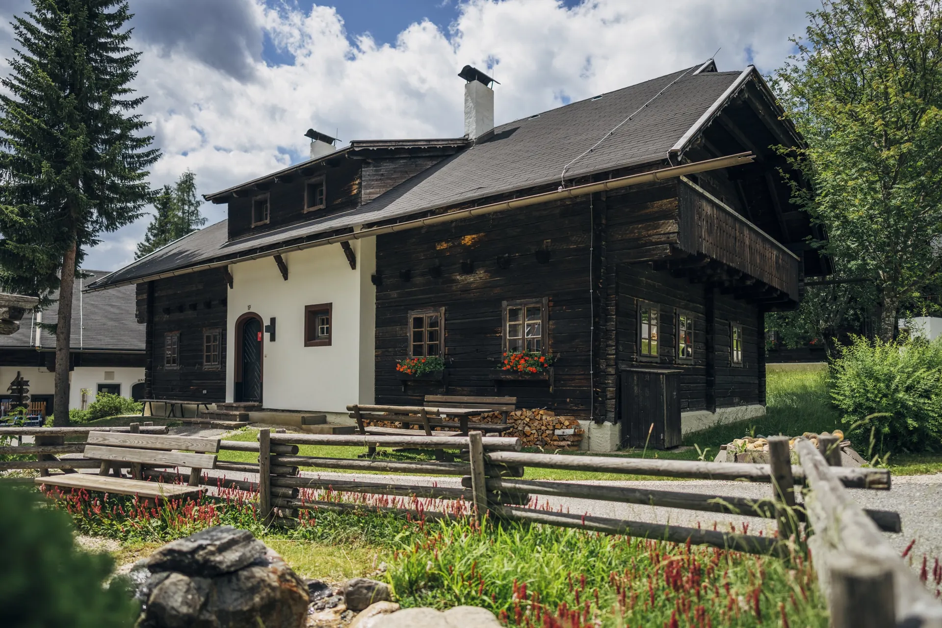 Holzhaus mit Zaun im Sommer