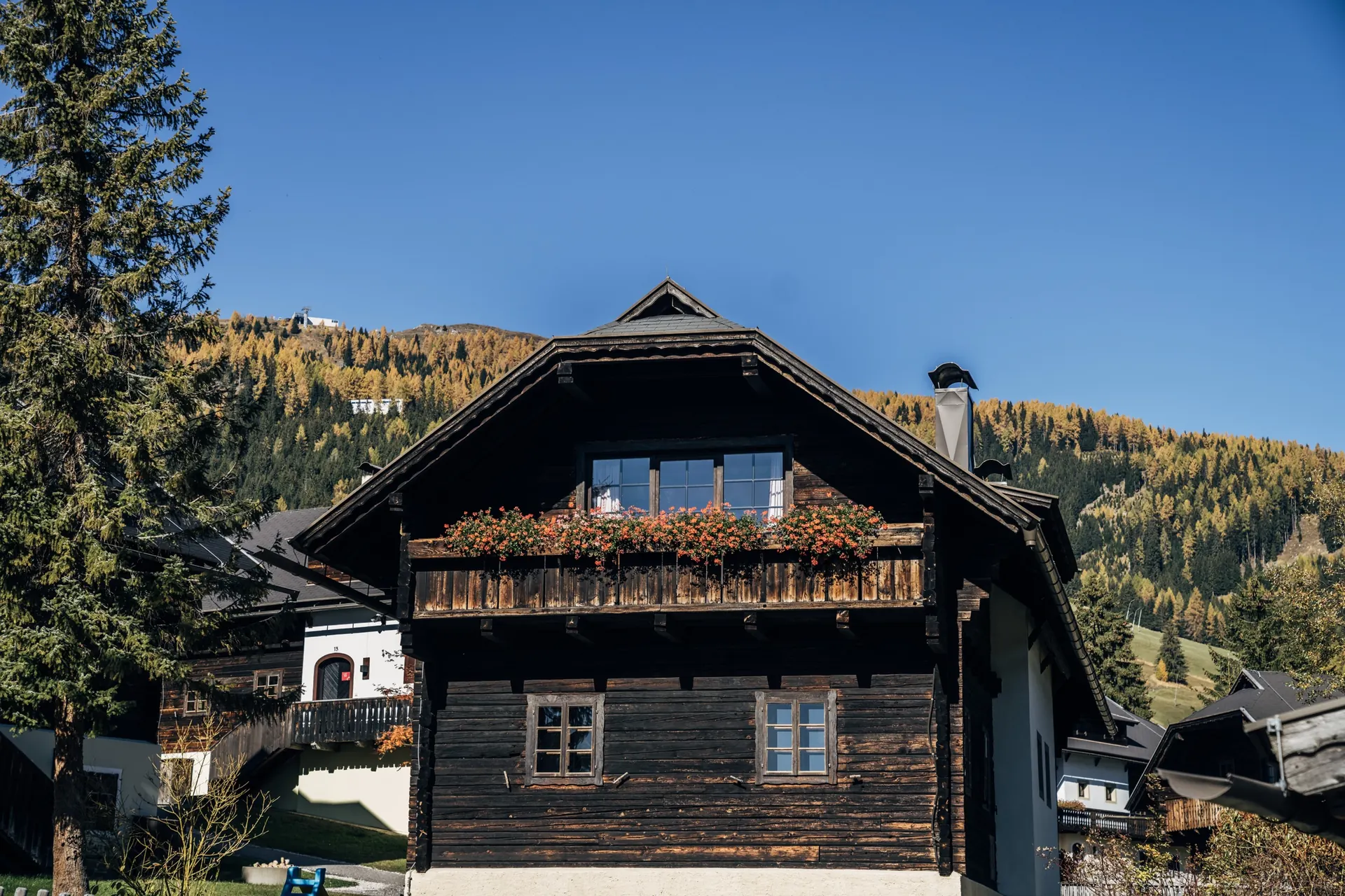 Altes Holzhaus mit Blumen am Balkon