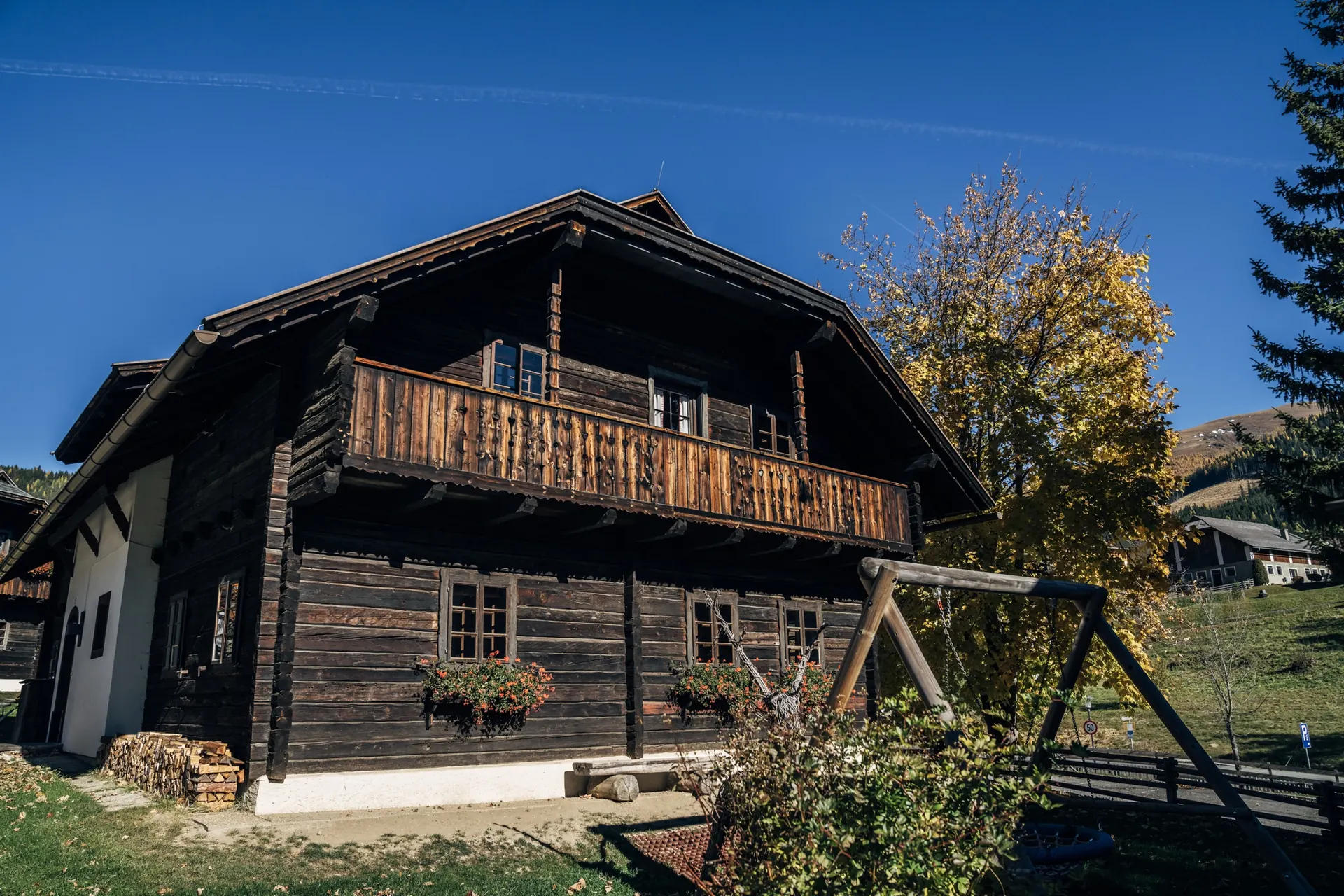 Holzhaus mit Balkon und Fichte