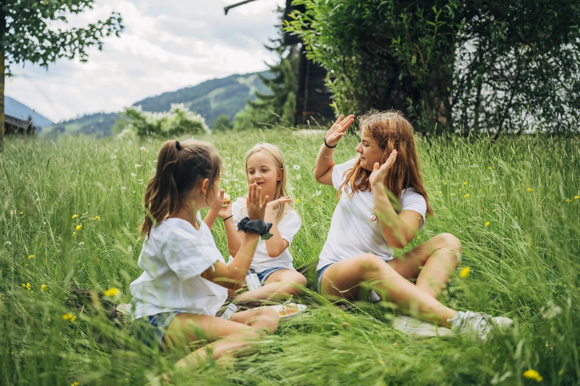 Drei Mädchen sitzen in der Wiese