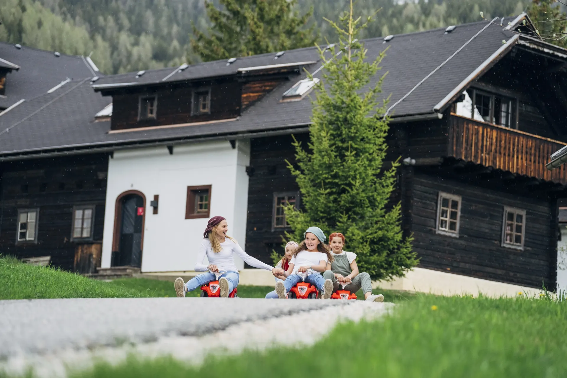 Mädchen mit Bobbycar vor dem Haus