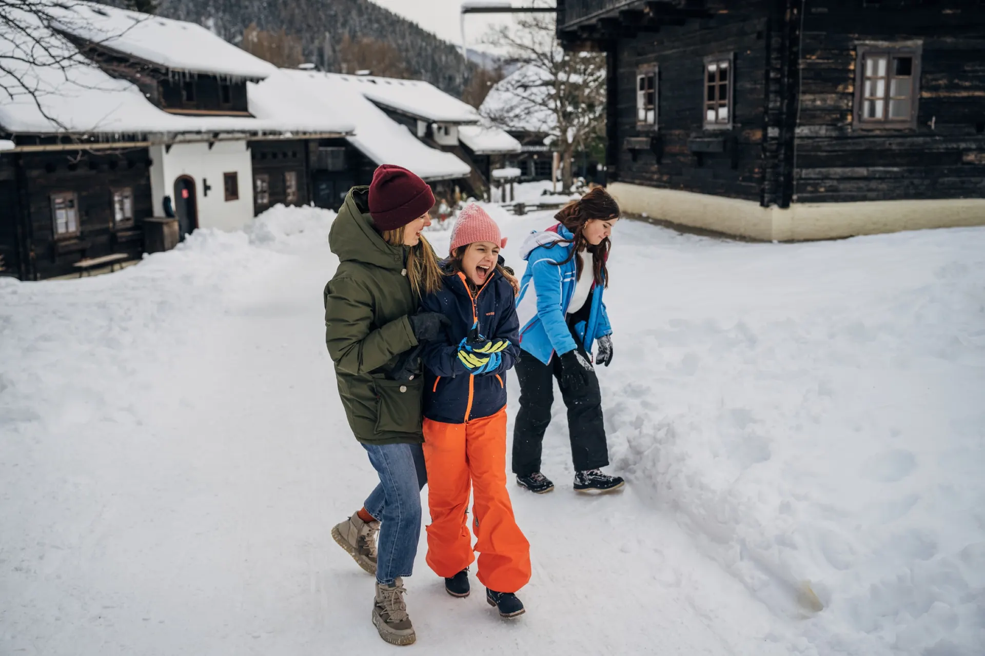 Familie im Schnee vor dem Haus
