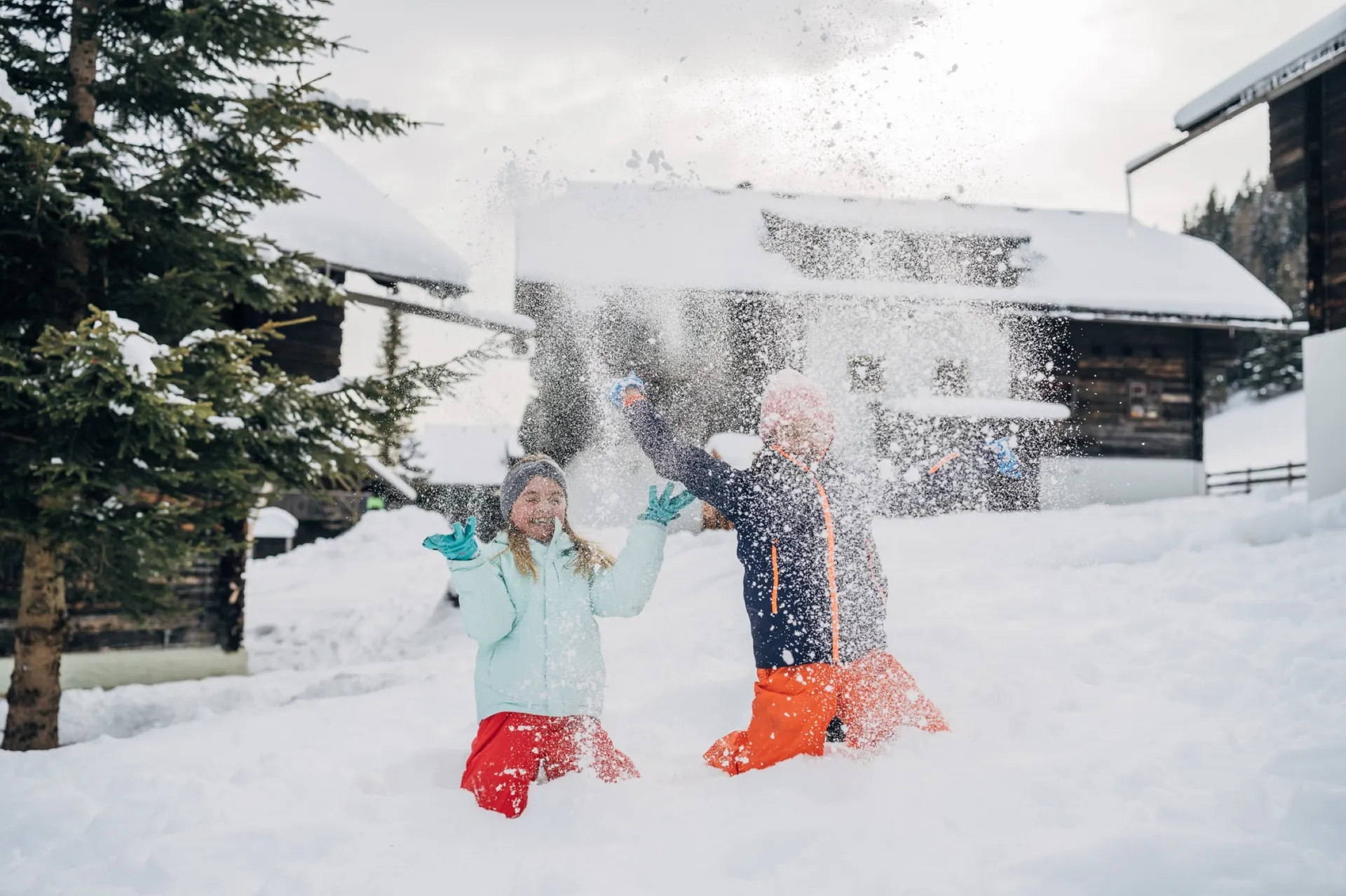 Kinder werfen Schnee in die Luft
