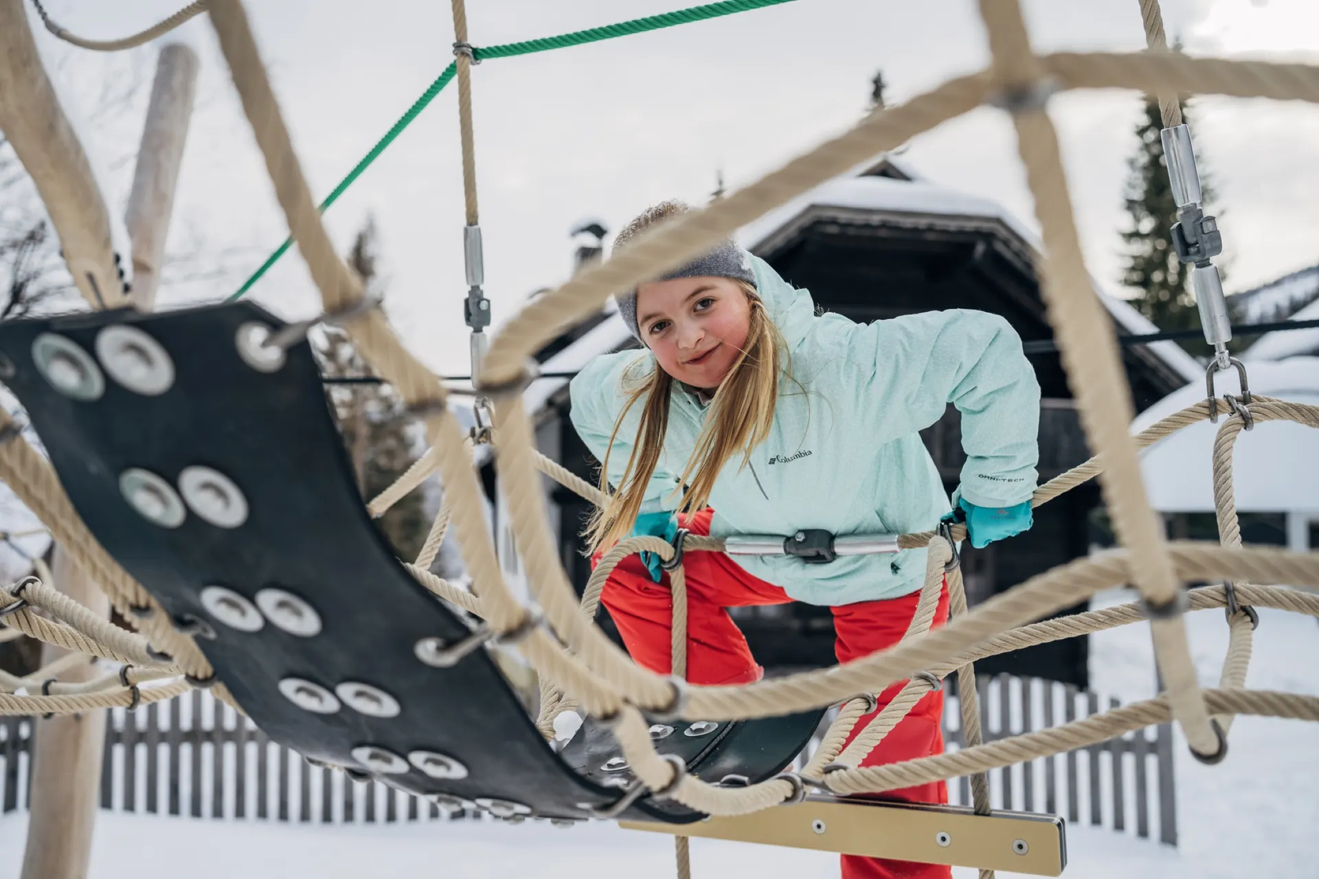 Kind im Kletternetz im Winter