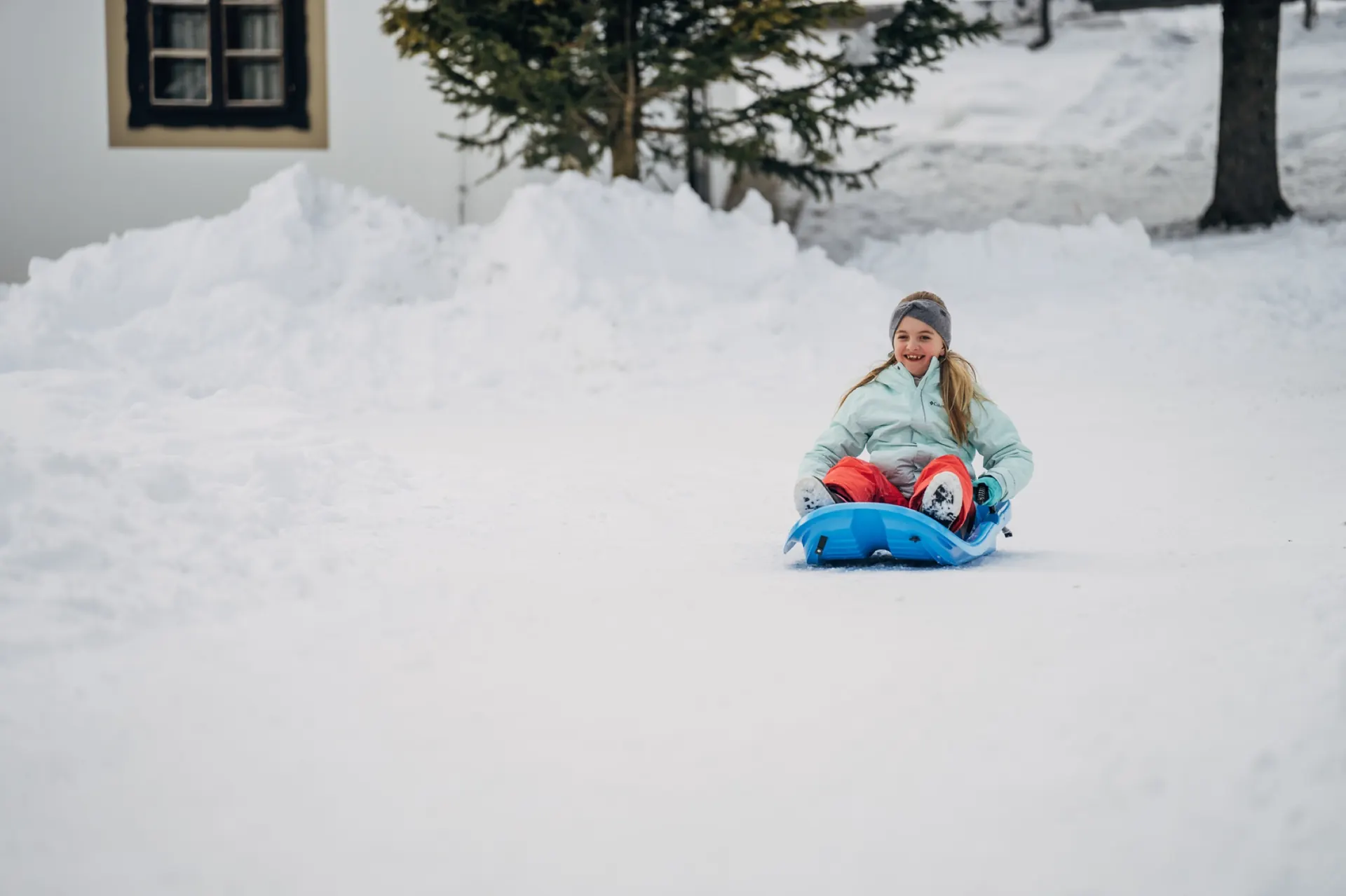 Kind rodelt im tiefen Schnee