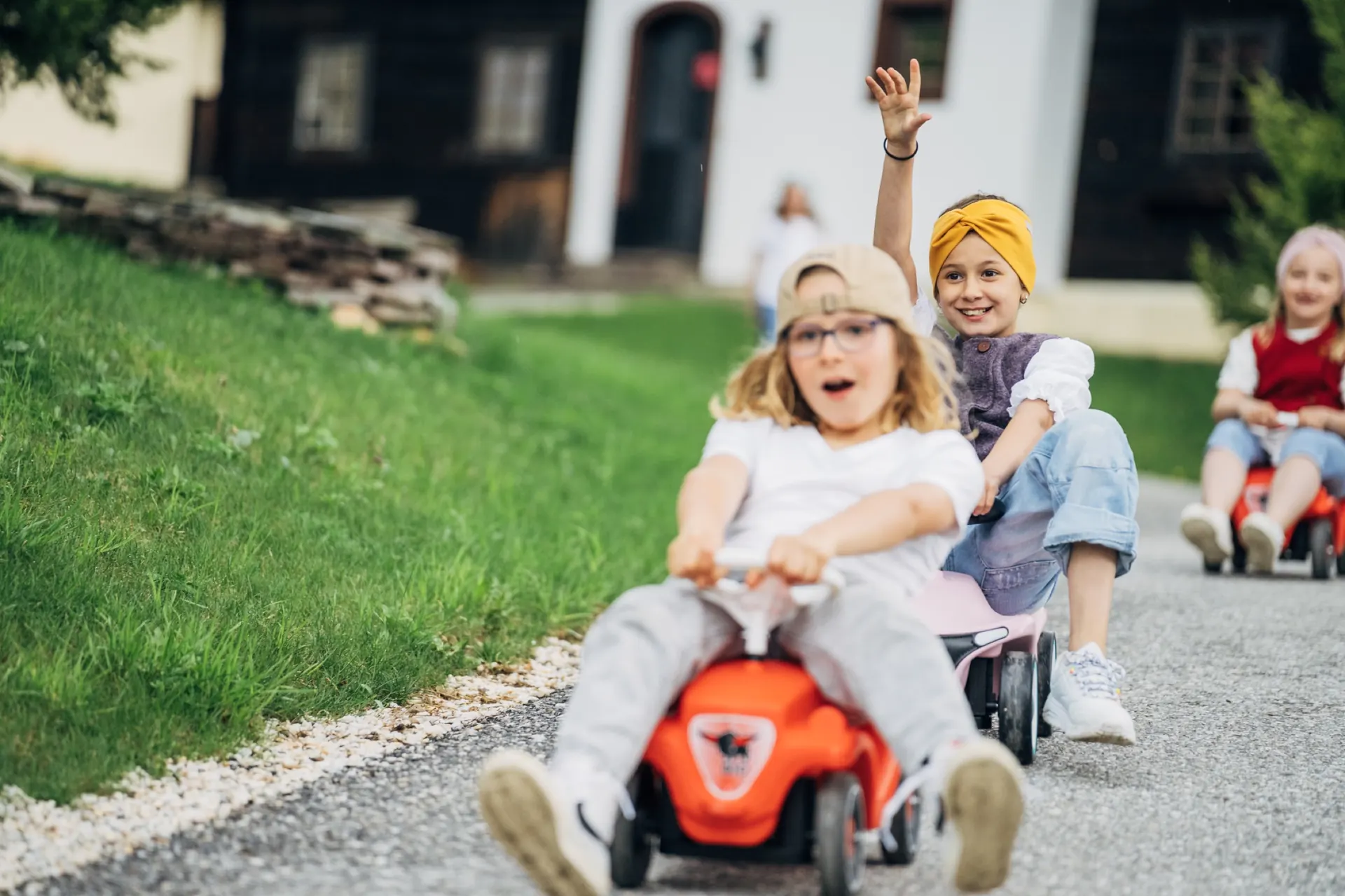 Kinder lachen auf den Bobbycars