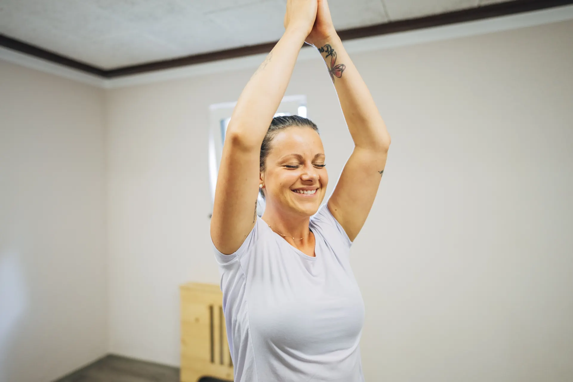Frau mit erhobenen Händen beim Yoga