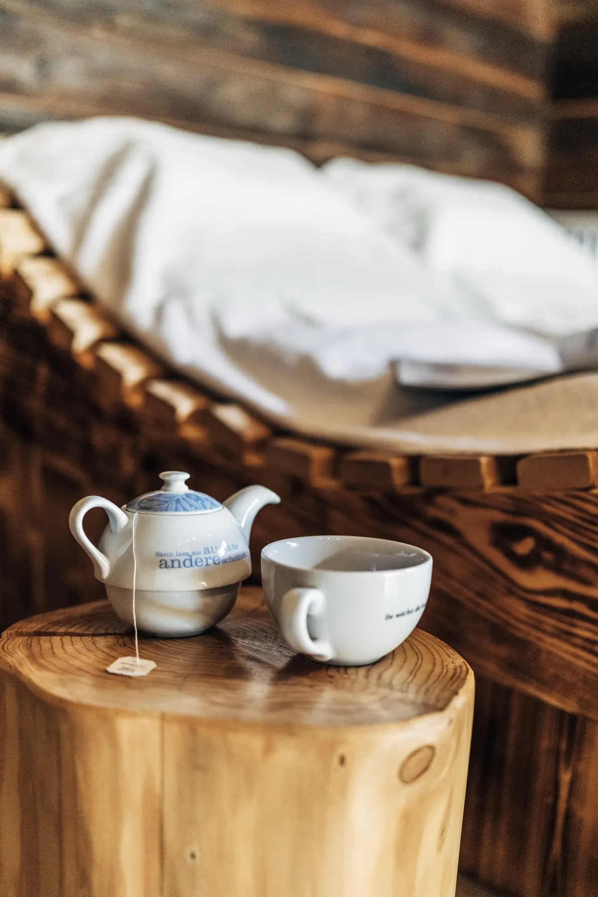 Teekanne und Tasse auf dem Holzstamm