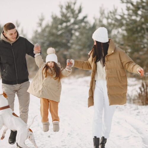 Familie beim Winterspaziergang durch die weiten Landschaften des Biosphärenparks Nockberge in Kärnten