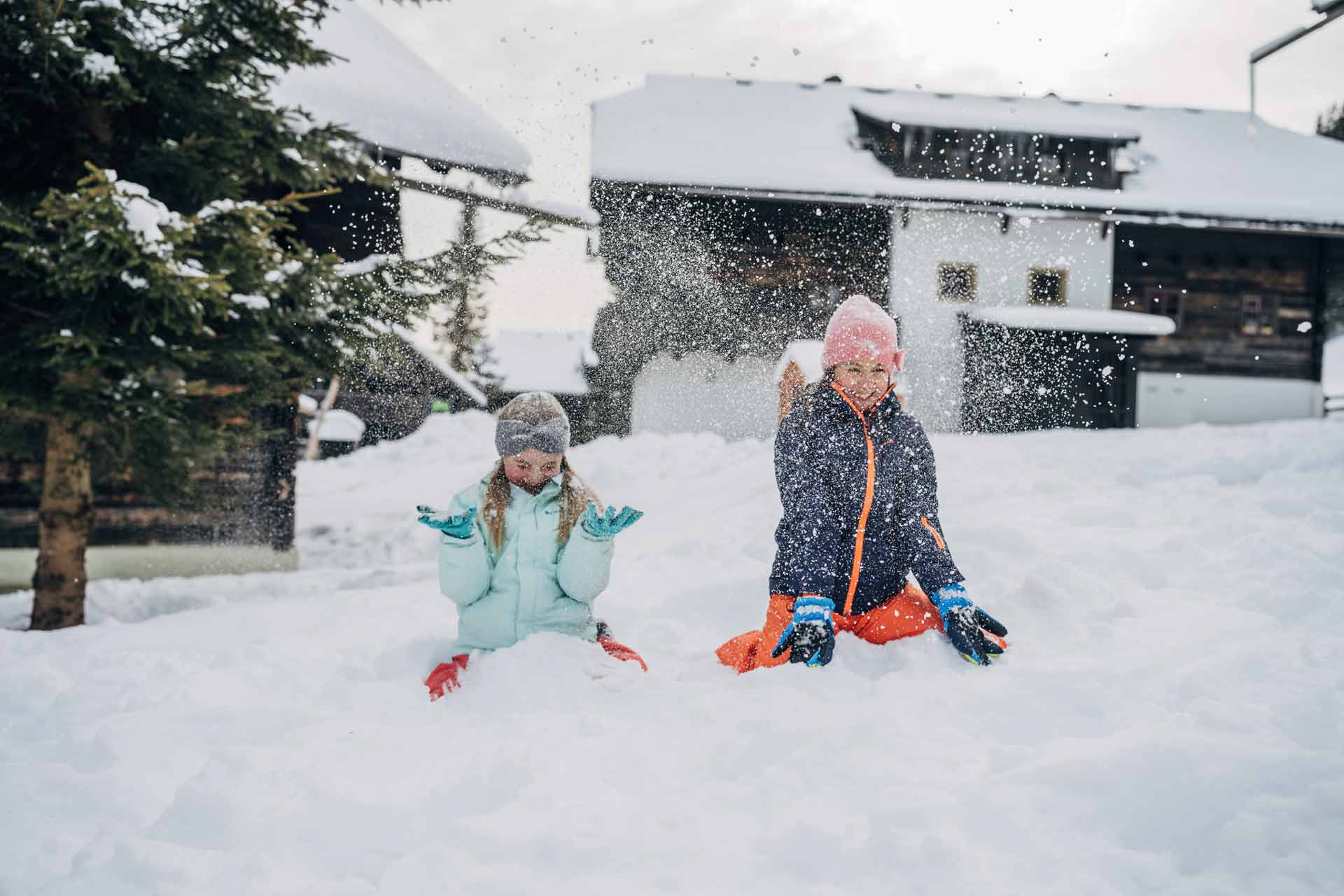 Urlaub mit Kindern im Feriendorf Kirchleitn im Winter, Mädchen spielen im Schnee