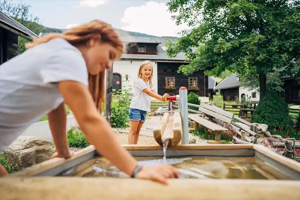 Family vacation in autumn in Austria, Carinthia – children play on the water playground in the Kirchleitn holiday village