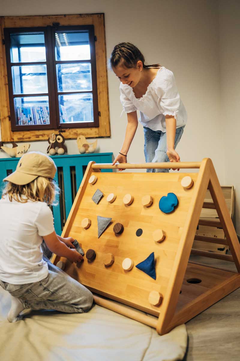 Area bambini interna a Kirchleitn Bambini che giocano con giocattoli in legno sostenibili nell'area bambini interna del villaggio vacanze Kirchleitn di Bad Kleinkirchheim