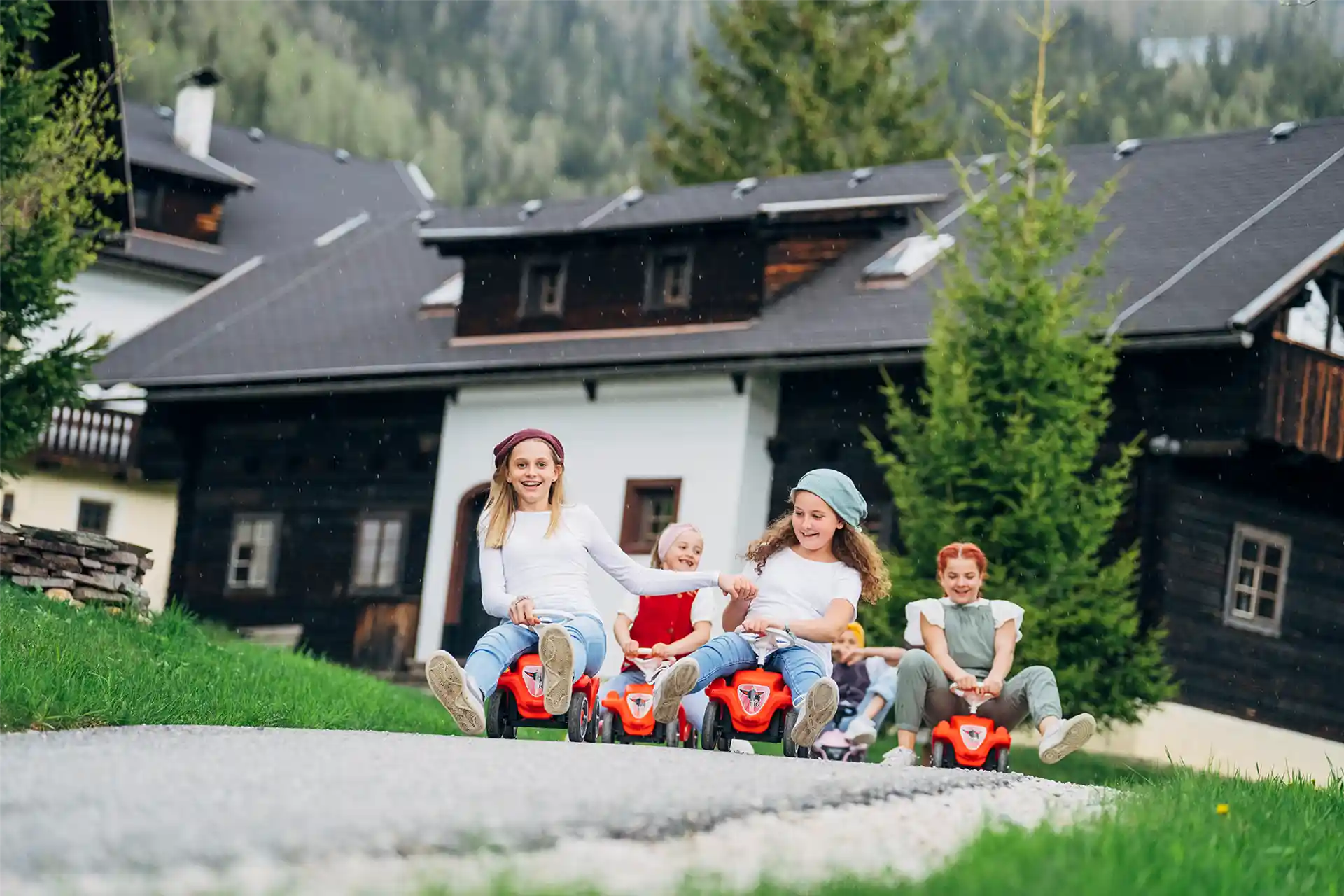 Kinder auf den Bobby Cars im Slow Travel Resort Kirchleitn beim Sommerurlaub in Kärnten