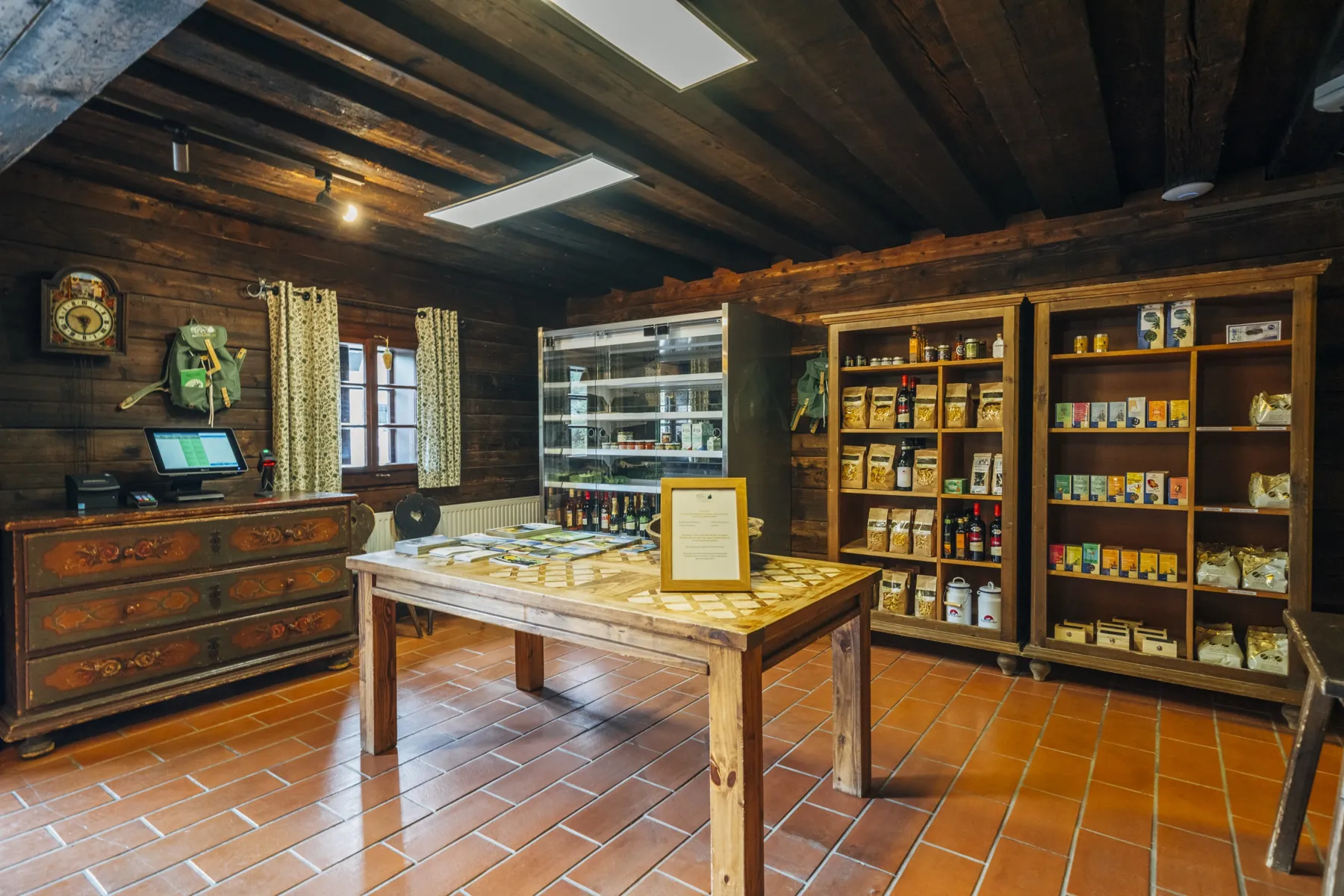 Die Greisslerei im Slow Travel Resort Kirchleitn: Hofladen mit Holzregalen und Terrakottaboden